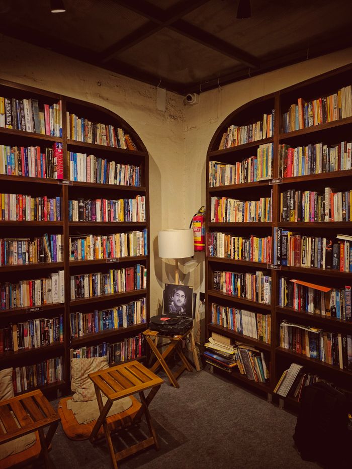 Warm, inviting library corner with wooden bookshelves filled with books and cozy seating.